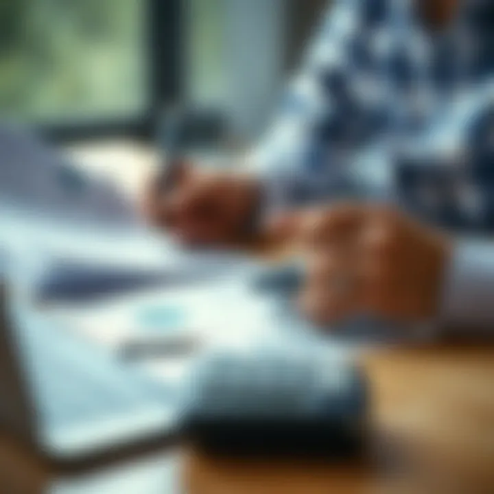 Person reviewing financial documents with calculator and laptop